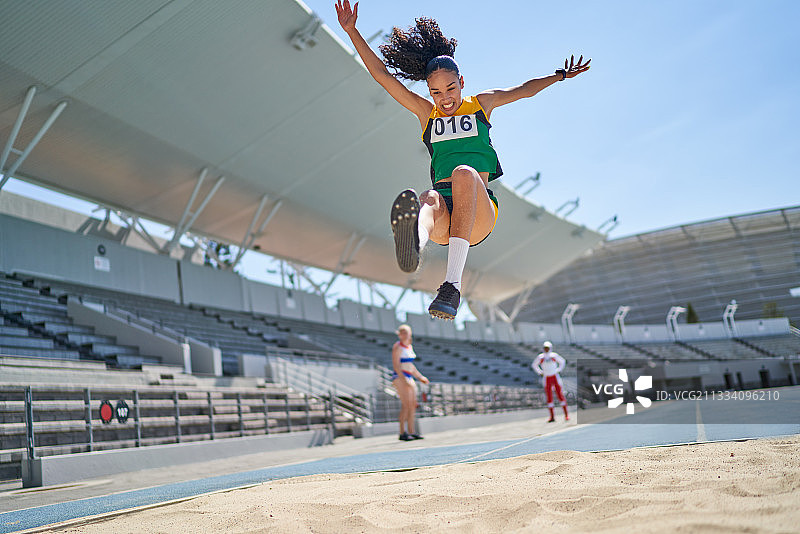 女田径运动员在沙地上跳远图片素材