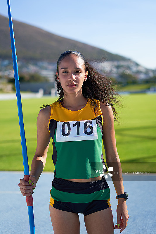 自信的女子田径运动员手持标枪的肖像图片素材