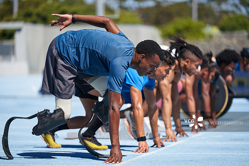 准备在阳光明媚的运动跑道起跑线上的截肢短跑运动员图片素材