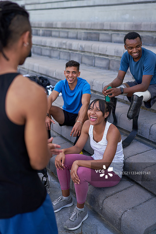 在台阶上交谈的快乐运动员图片素材