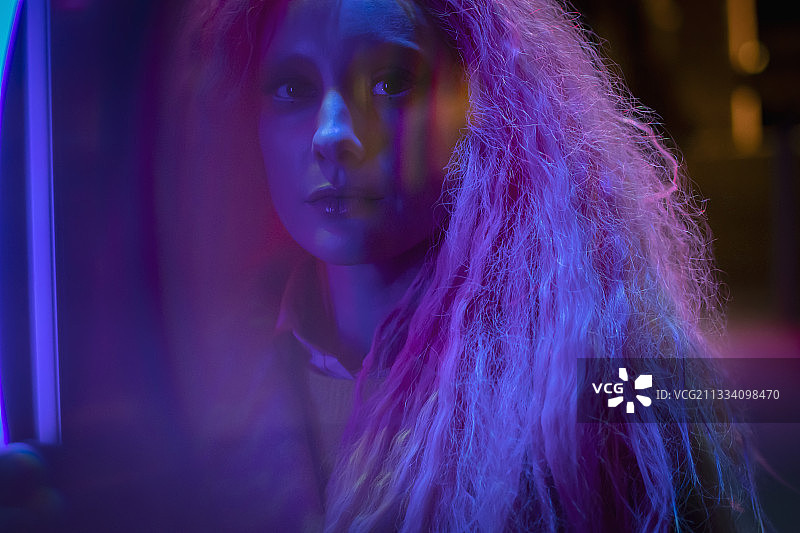 霓虹灯下粉色头发的神秘美女画像图片素材