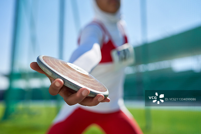 田径女运动员掷铁饼特写图片素材