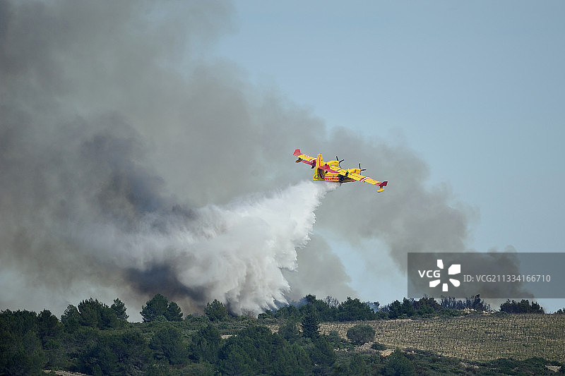 加拿大飞机在法国灌木丛火灾上投掷阻燃剂图片素材