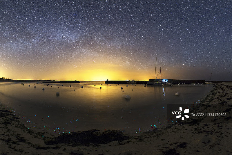 磷光浮游生物照亮了小波浪死亡的海岸。天空中，银河天蝎座天鹅。图片素材