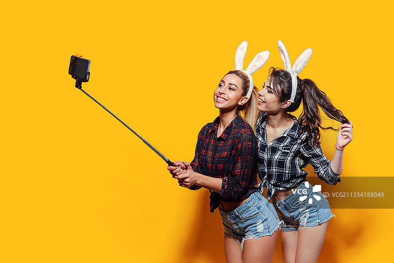 粉色背景前穿着服装的女性朋友肖像图片素材