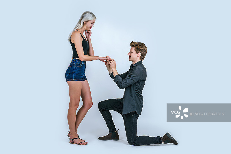 男子牵着女子的手，灰色背景图片素材