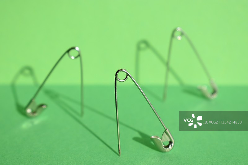 绿色背景上的安全别针特写图片素材
