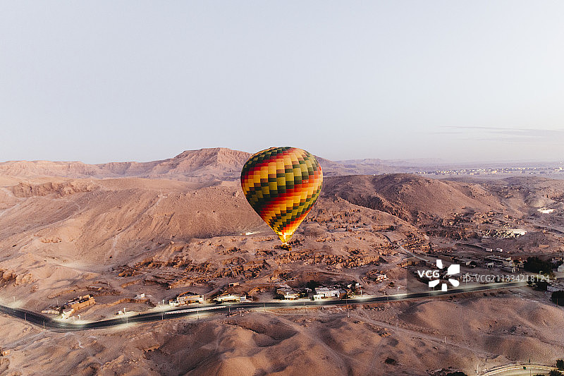 热气球飞越景观的鸟瞰图，晴朗天空为背景图片素材