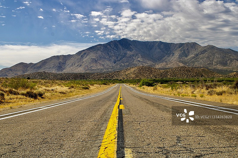 空无一人的路，通向高耸入云的山峰图片素材