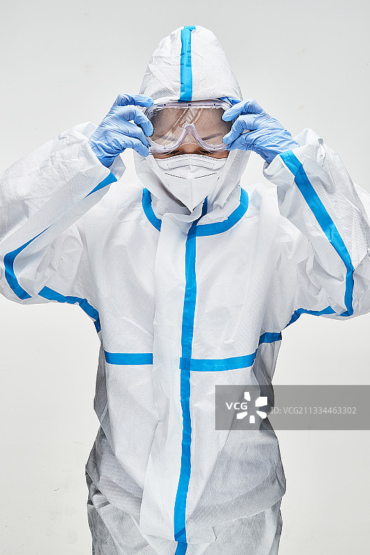 穿白色防护服佩戴护目镜口罩的女性医疗人员图片素材