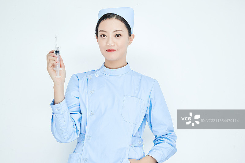 穿护士服戴口罩手执针筒的年轻女护士图片素材
