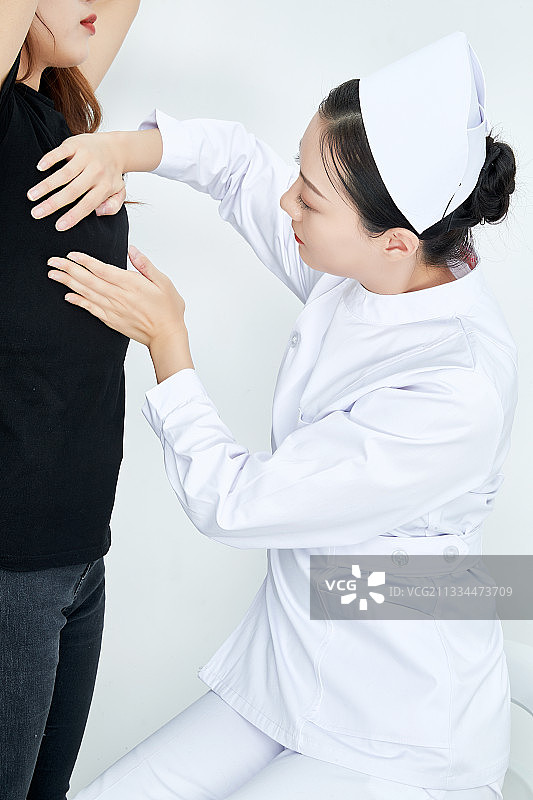 年轻的女性医护人员为患者进行胸部检查图片素材