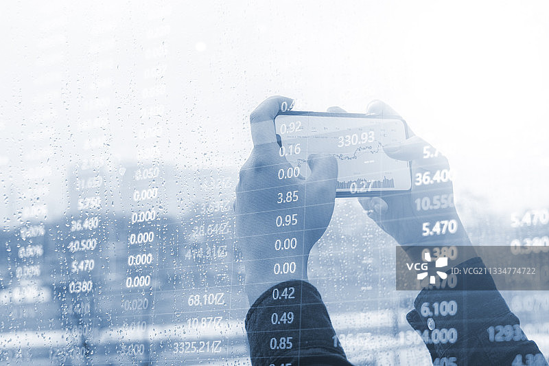 投资者拿智能手机进行金融股票交易买卖图片素材