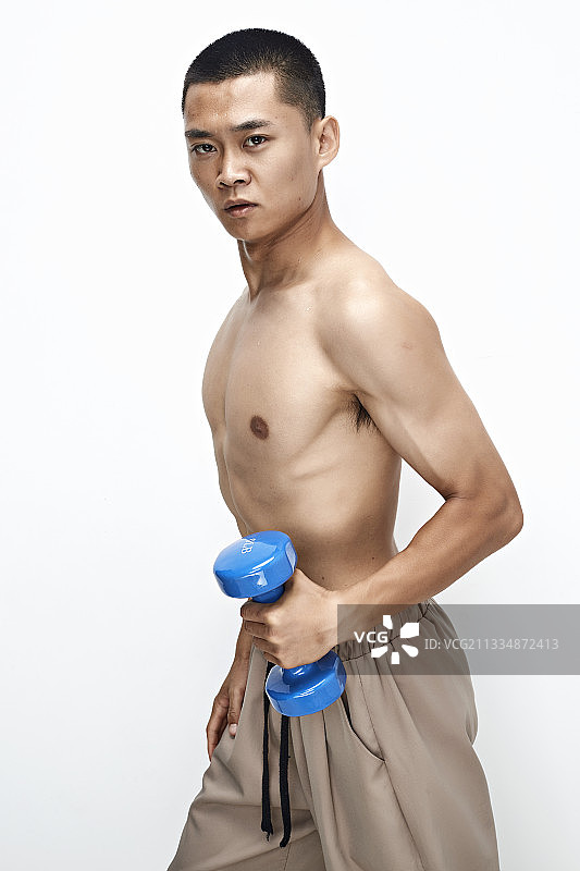 使用哑铃进行健身锻炼的亚洲男性图片素材