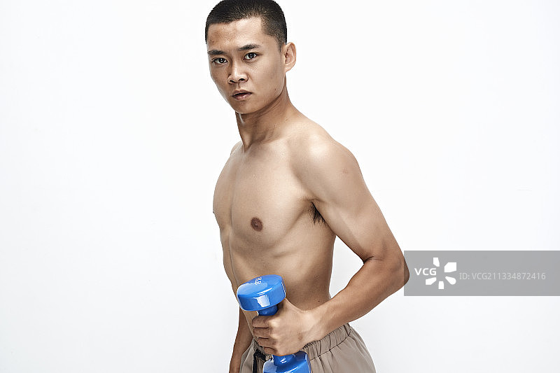 使用哑铃进行健身锻炼的亚洲男性图片素材