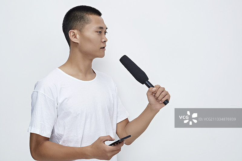手持话筒手机进行采访的新闻工作者图片素材