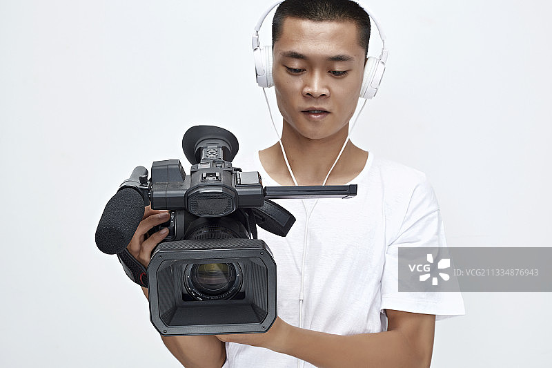 白色背景下手持摄像机进行录制拍摄的摄像师图片素材