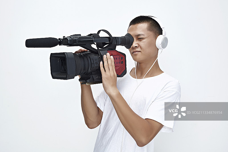 白色背景下手持摄像机进行录制拍摄的摄像师图片素材