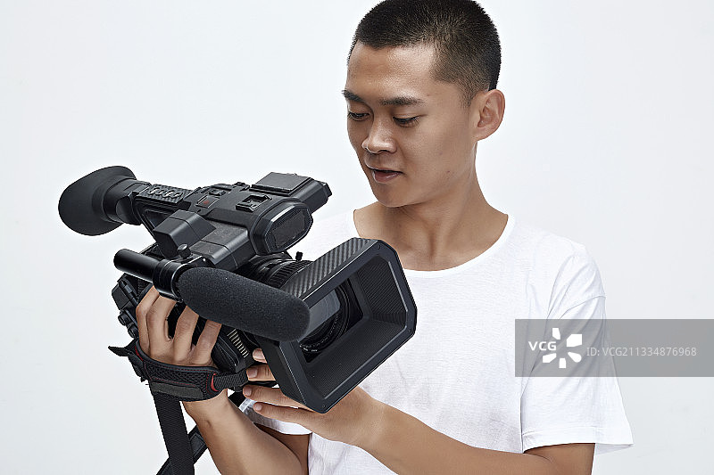白色背景下手持摄像机进行录制拍摄的摄像师图片素材