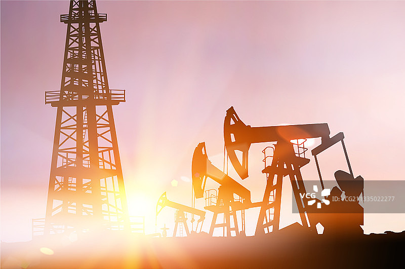 日落时分的石油钻井平台和油泵轮廓图片素材