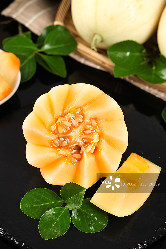 黑石板上放着切开的阎良甜瓜图片素材