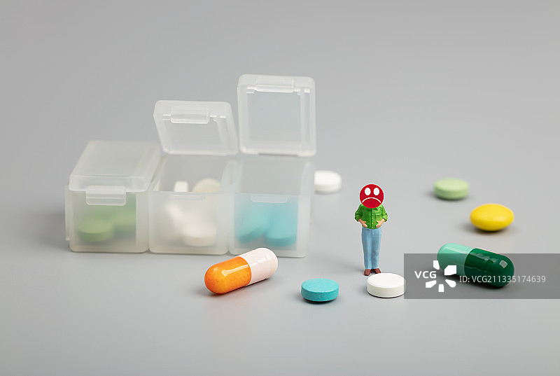 微缩创意看着药片焦虑的大肚腩肥胖男性图片素材