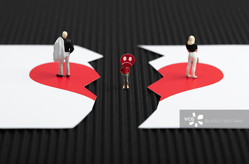 微缩创意破裂的红心上离婚的夫妻与悲伤的孩子图片素材