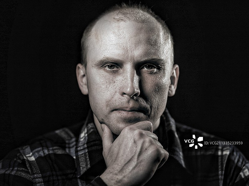 肖像：表情严肃的男子，黑色背景，乌克兰图片素材