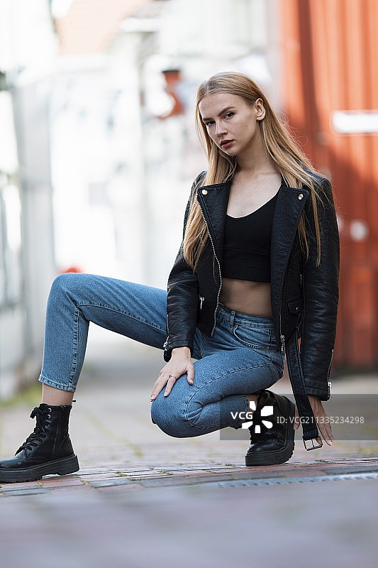 年轻女子坐在挪威格里姆斯塔街头的肖像图片素材