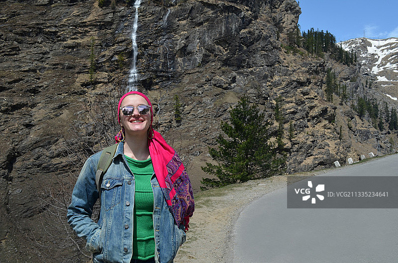 微笑的女人站在山路上的肖像图片素材