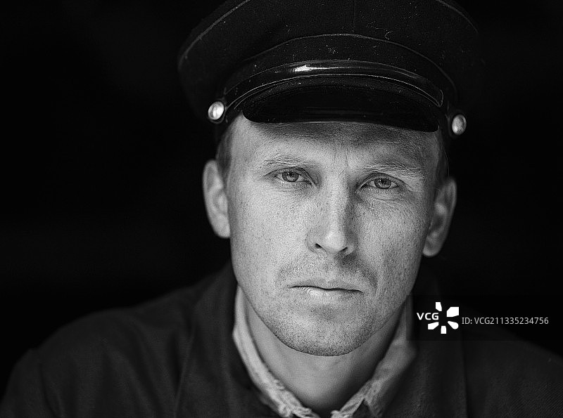 戴帽男子在黑色背景下的特写肖像，乌克兰图片素材