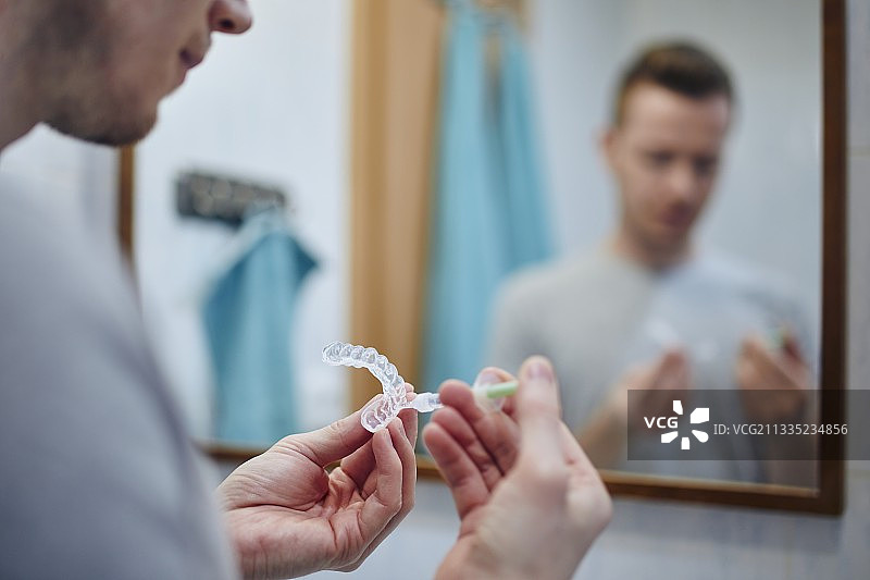 男子准备用于牙齿美白的硅胶托盘图片素材