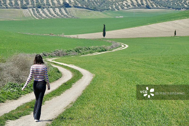在西班牙格拉纳达的步行道上行走的女子背影图片素材