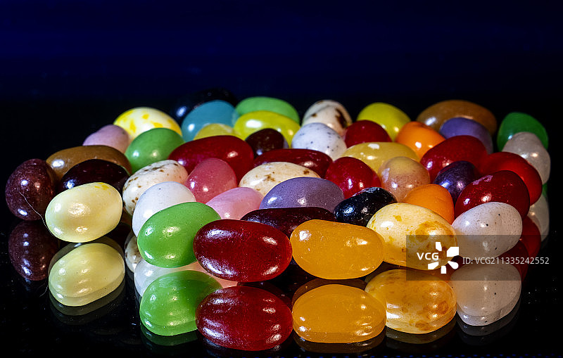 黑色背景上的彩色软糖豆特写图片素材