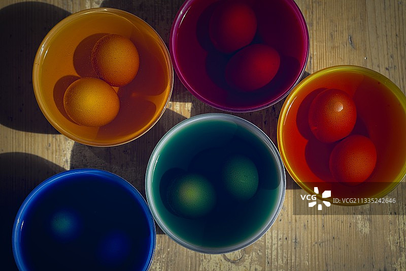 桌子上容器中彩色鸡蛋的俯视照片，德国图片素材