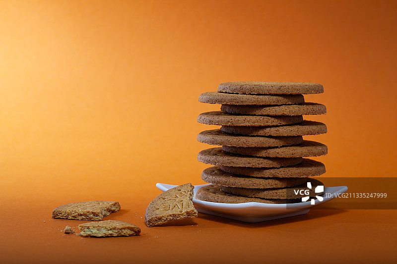 橙色背景下的桌子上饼干特写图片素材