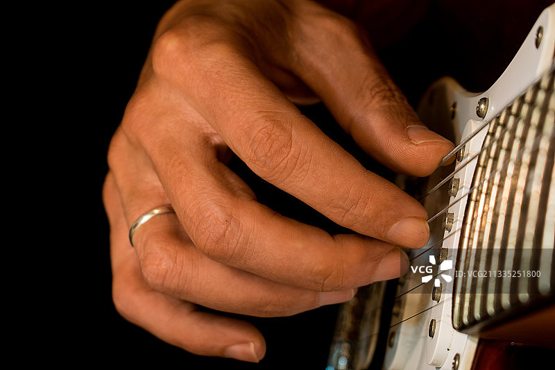 男子弹吉他的腰部特写图片素材