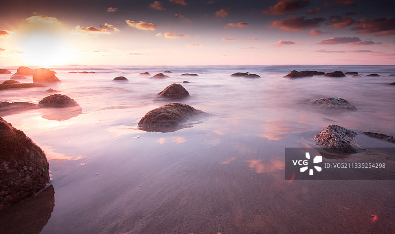 西班牙日落时天空映衬着大海的美景图片素材