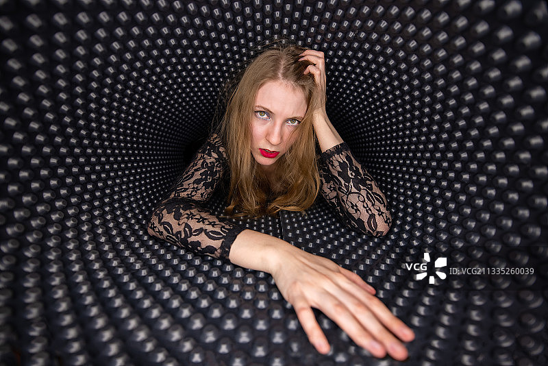 年轻女子躺在图案隧道中的肖像图片素材