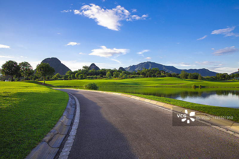 蓝天白云下草坪中的道路图片素材