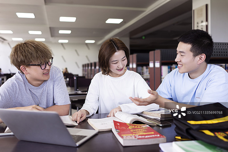 几个大学生在图书馆讨论问题图片素材