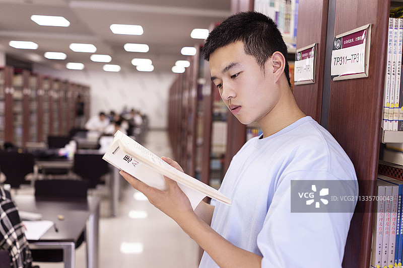 男大学生在图书馆看书图片素材