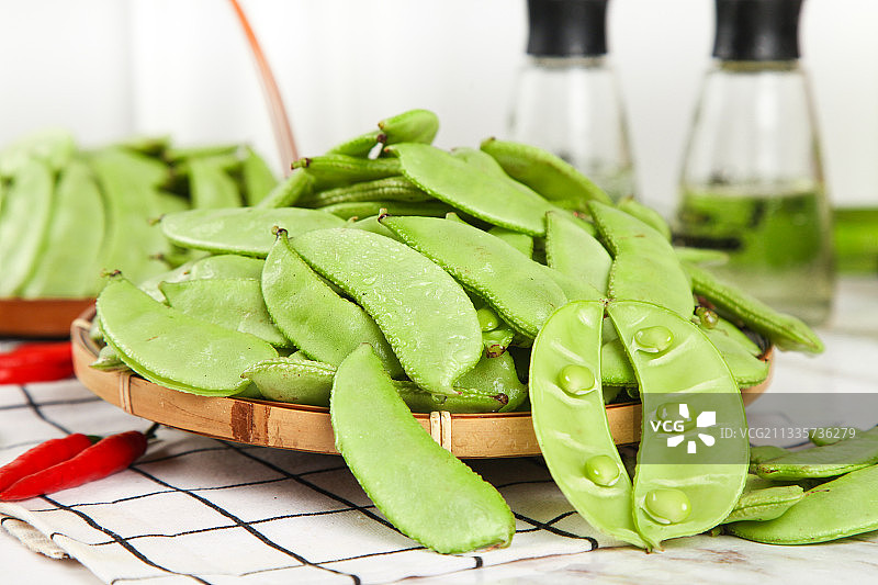 格子底上摆放着扁豆角图片素材