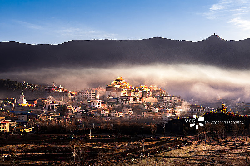 晨光、晨雾、炊烟与葛丹·松赞林寺图片素材