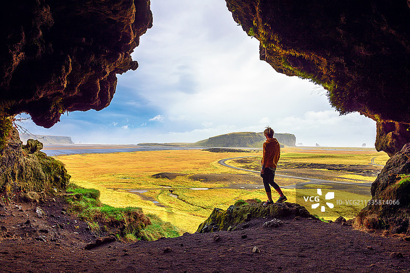 男子站在岩石上，背景是天空图片素材