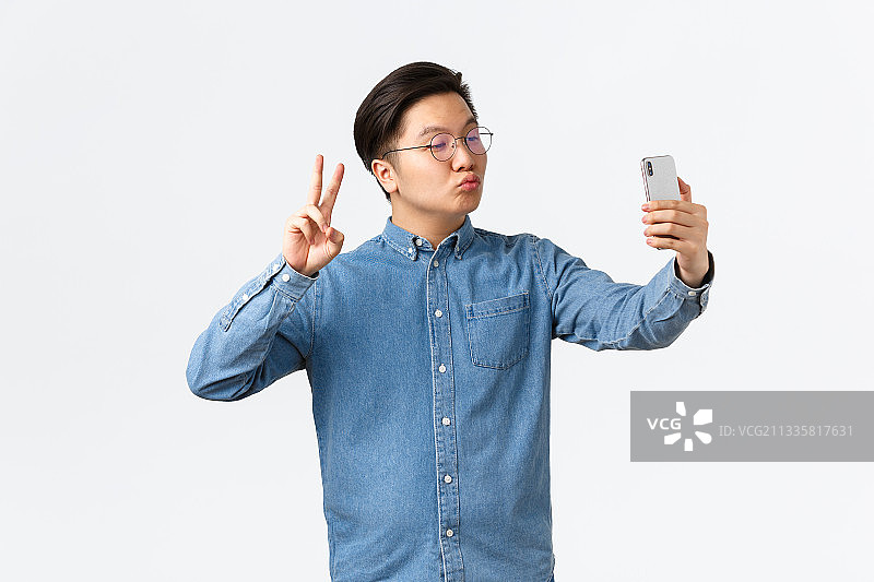 快乐的亚洲年轻男子在白色背景上悠闲自在图片素材