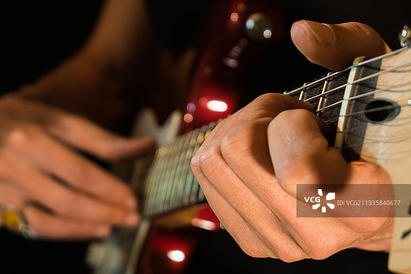 男子弹吉他的腰部特写图片素材