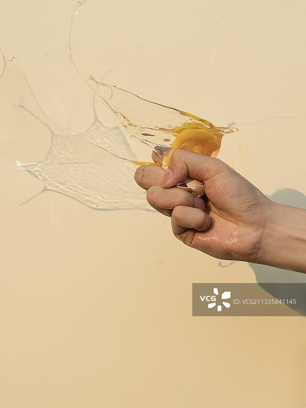 食物浪费概念：手压碎鸡蛋图片素材