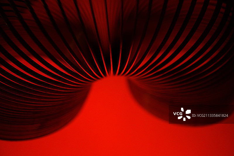 红色背景下的金属线圈特写图片素材