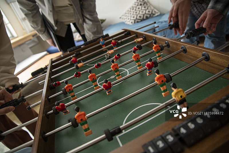 年轻人玩桌上足球图片素材
